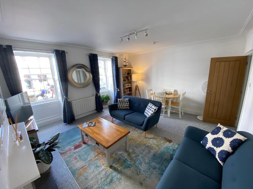 法尔茅斯Bank Place的客厅配有蓝色的沙发和桌子