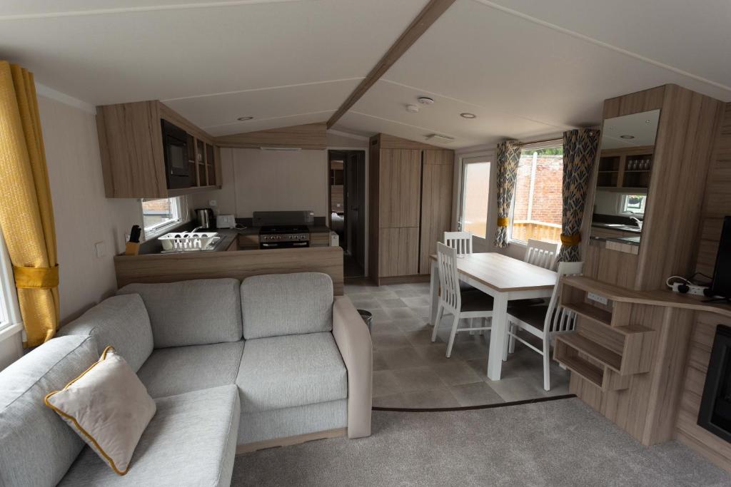 阿伯劳尔The Fly Van - Beautiful, luxury static caravan的带沙发的客厅和厨房