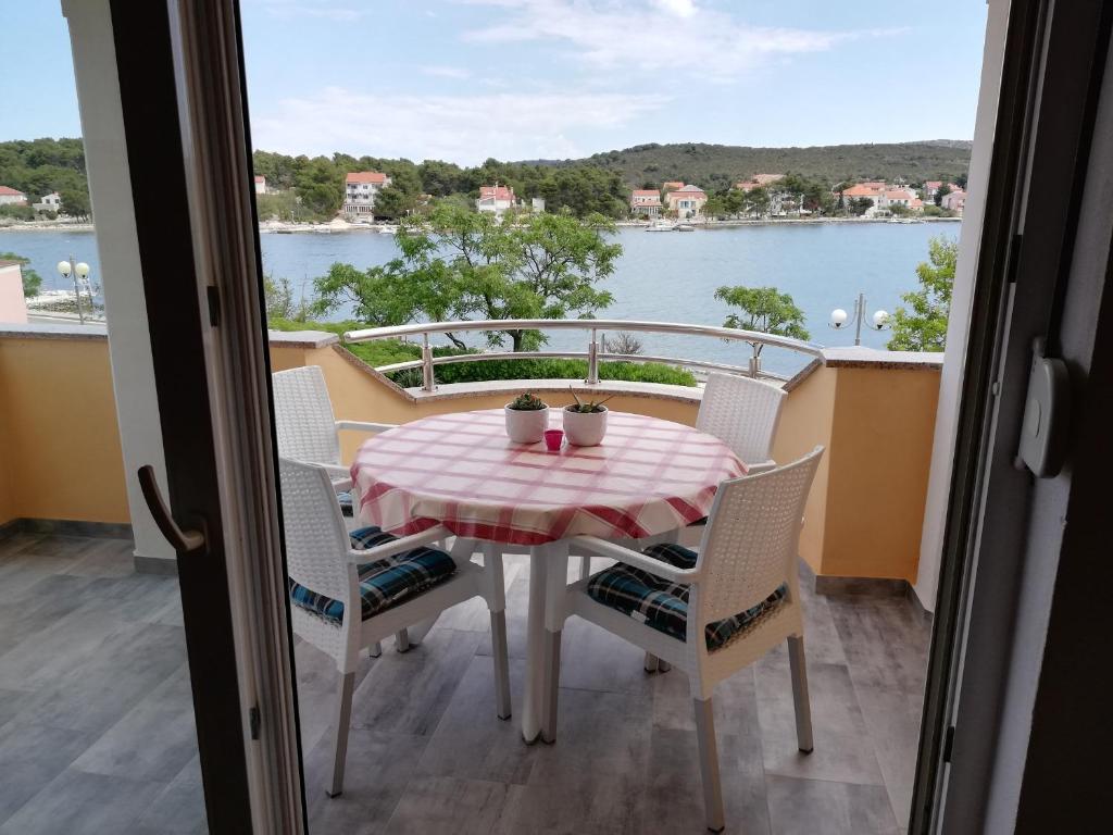 韦利拉特Apartments Marijan - sea view的阳台配有桌椅,享有水景