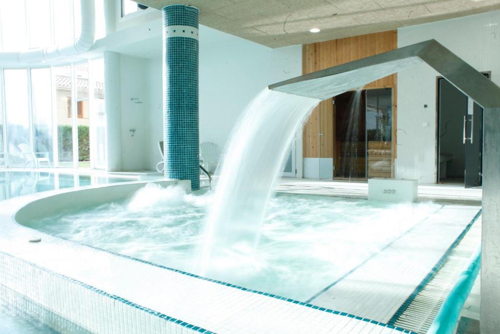 罗萨斯HOTEL & APARTAMENTS THALASSA Sport & Spa的游泳池中的喷泉