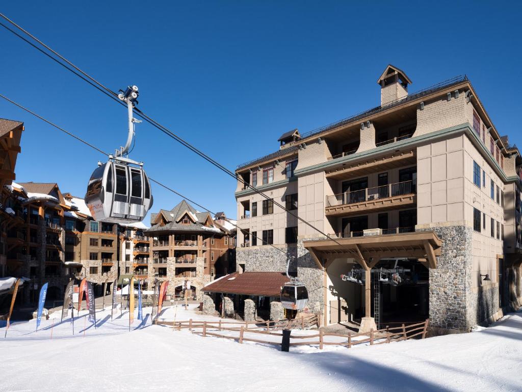 特拉基The Residences at One Village Place by Hyatt Vacation Club的雪中建筑物前面的滑雪缆车