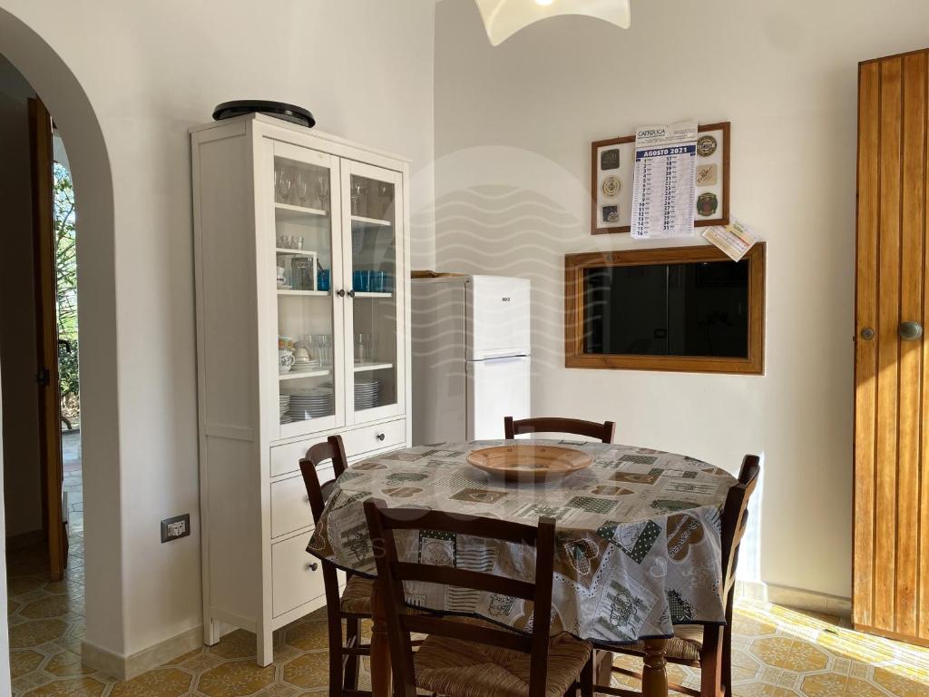 托雷拉皮罗Villa Sunshine的厨房配有桌椅和冰箱。