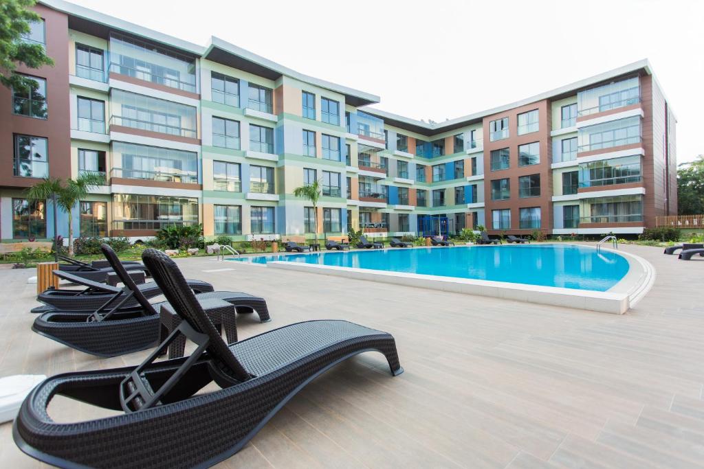 阿克拉Accra Luxury Apartments @ Pearl的大楼前带躺椅的游泳池