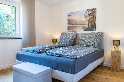 贝尔恩卡斯特尔-库斯Weinrebe的卧室配有一张蓝色的床,墙上挂着一幅画