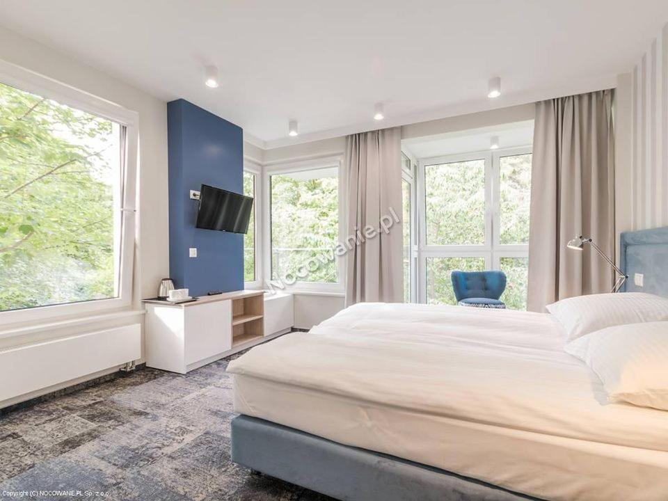 拉塔Pensjonat Przedwiośnie的一间卧室设有一张大床和蓝色的墙壁