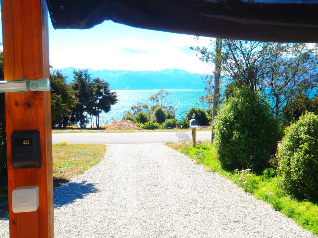 哈威亚湖Lakefront Fantail Cottage Lake Hawea, Wanaka的一条享有水景的碎石路