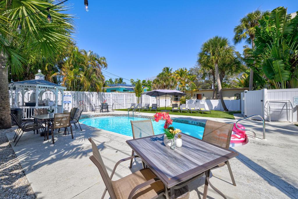 西耶斯塔岛林格林海滩公寓的一个带木桌和椅子的庭院,毗邻一个游泳池