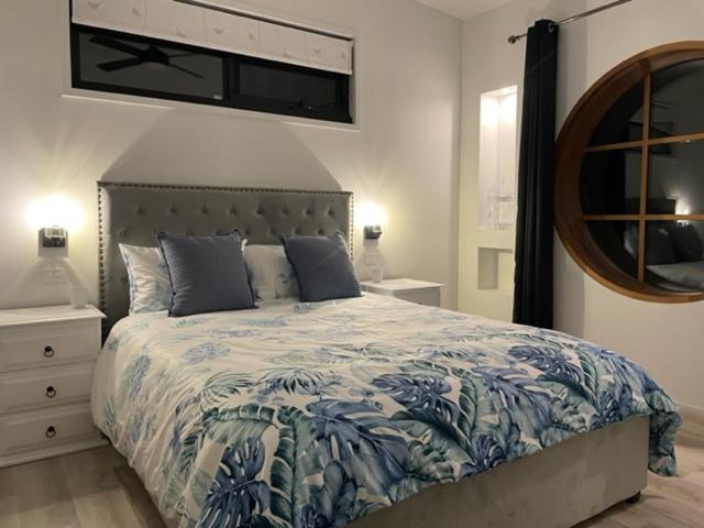 亚伯Farm Stay POPLAR Cottage at Wilindi Estate的一间卧室配有一张带蓝色和白色棉被的床