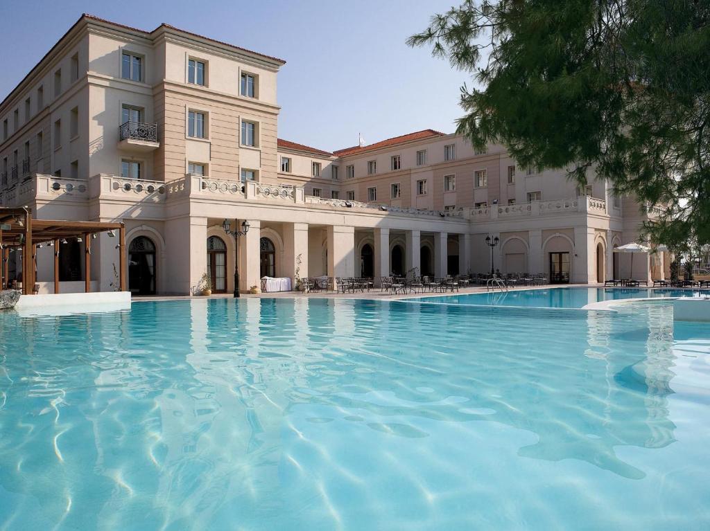 拉里萨Grecotel Larissa Imperial的大楼前的大型游泳池