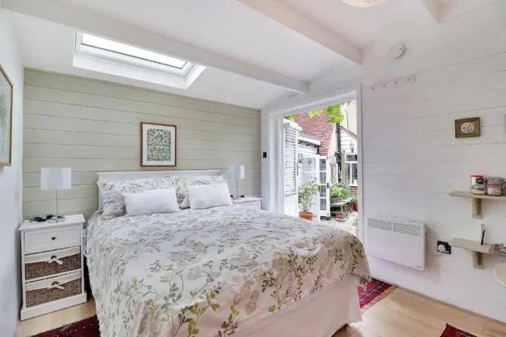 克兰布鲁克Garden Studio的一间卧室设有一张大床和一个窗户。
