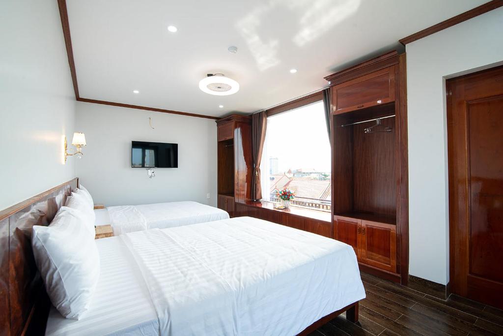 洞海Minh Quang Hotel的一间卧室设有两张白色的床和窗户