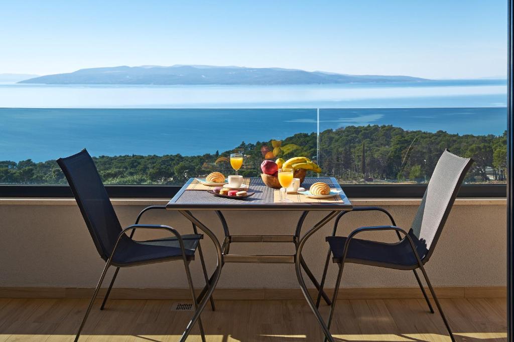 马卡尔斯卡Sun Spalato Residence的一张餐桌和两把椅子,享有海景