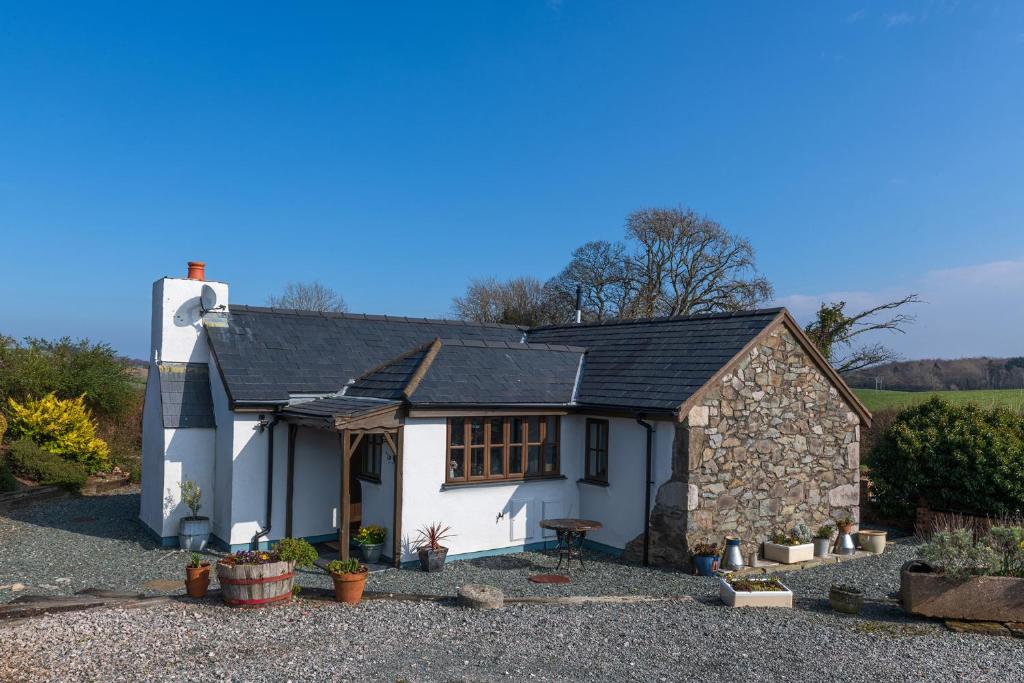 阿贝尔格莱Beautiful Countryside cottage on the North Wales Coast的白色小屋 - 带黑色屋顶