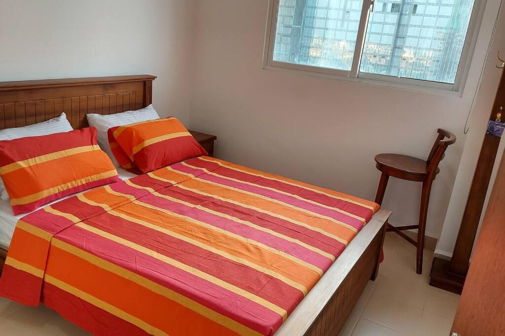 科伦坡Jays Apartment - Colombo 02 at the heart of convenience的一间卧室配有一张带彩色条纹毯子的床