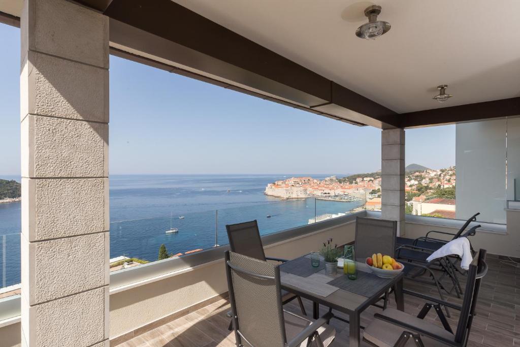 杜布罗夫尼克Amorino Of Dubrovnik Apartments的阳台配有桌椅,享有海景。