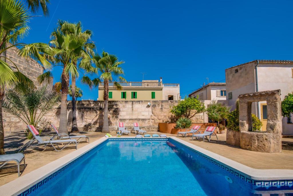 马里亚德拉萨卢特Ideal Property Mallorca - Verdera的一个带椅子的游泳池和一个背景房子