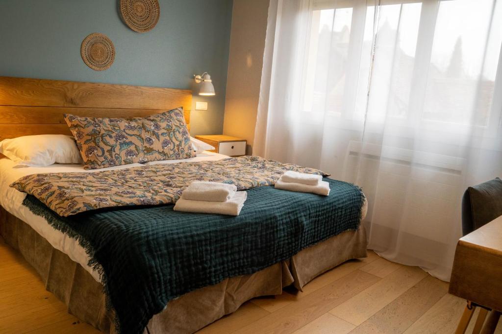 罗卡马杜尔Logis Hôtels - Le Belvédère - Hôtel 2 étoiles et Restaurant的一间卧室，床上有两条毛巾