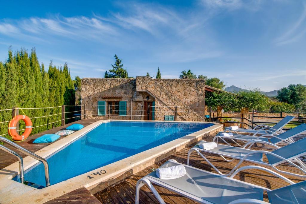 阿尔库迪亚Ideal Property Mallorca - Sa Vinya Vella的一个带椅子的室外游泳池和一个泳池景泳池