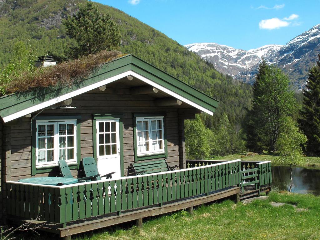 HolsenChalet Fjellro - FJS103 by Interhome的小木屋设有草地屋顶和门廊上的椅子
