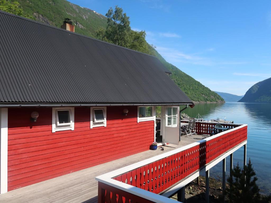 ArnefjordHoliday Home Njord - FJS603 by Interhome的水体旁码头上的红色房子