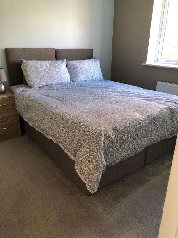 Brettell LaneHill House - 5 Mins Merry Hill - Perfect for Contractors & Families的卧室内的一张大床,配有床罩