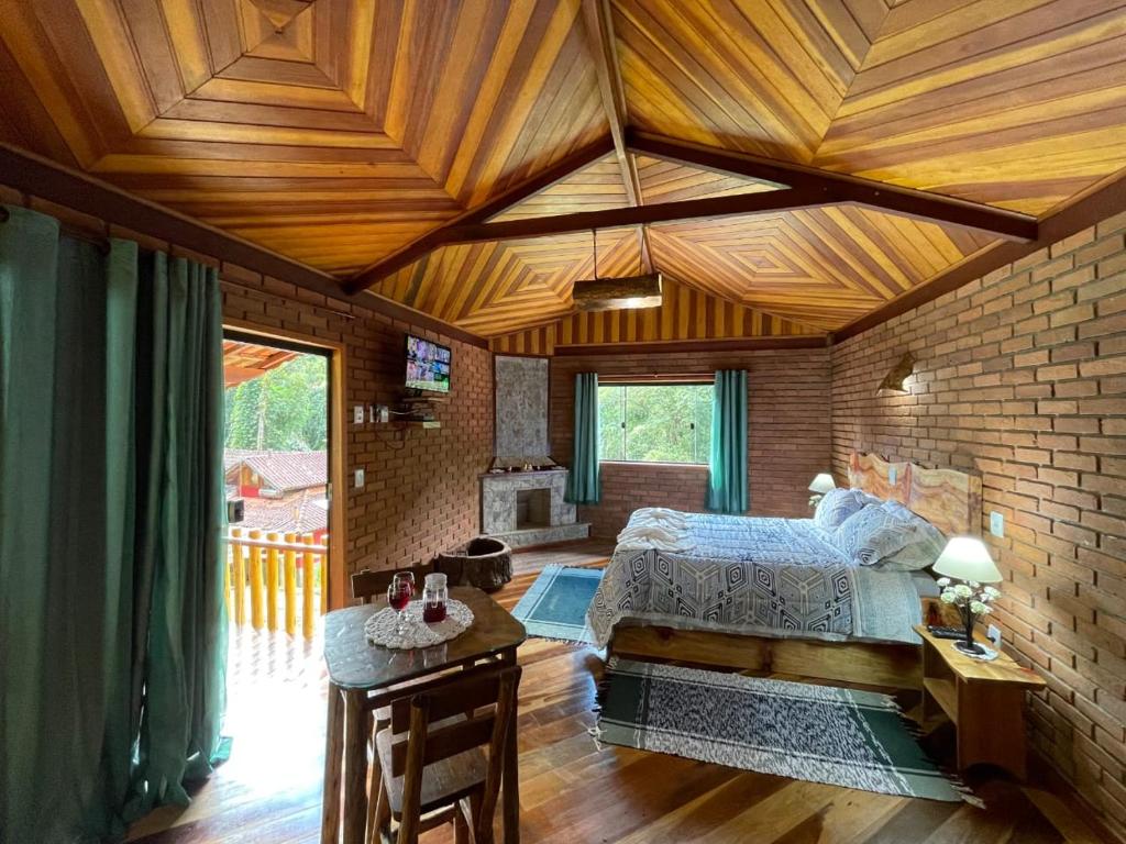 维奥康德马奥Chalé rústico truta dá floresta 3的一间卧室设有一张床和木制天花板