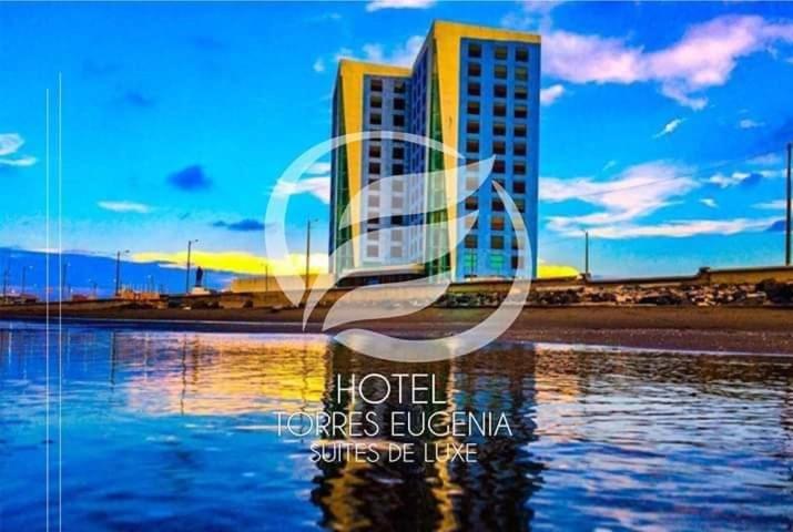 夸察夸尔科斯Hotel Torres Eugenia的水中反射的建筑物的照片
