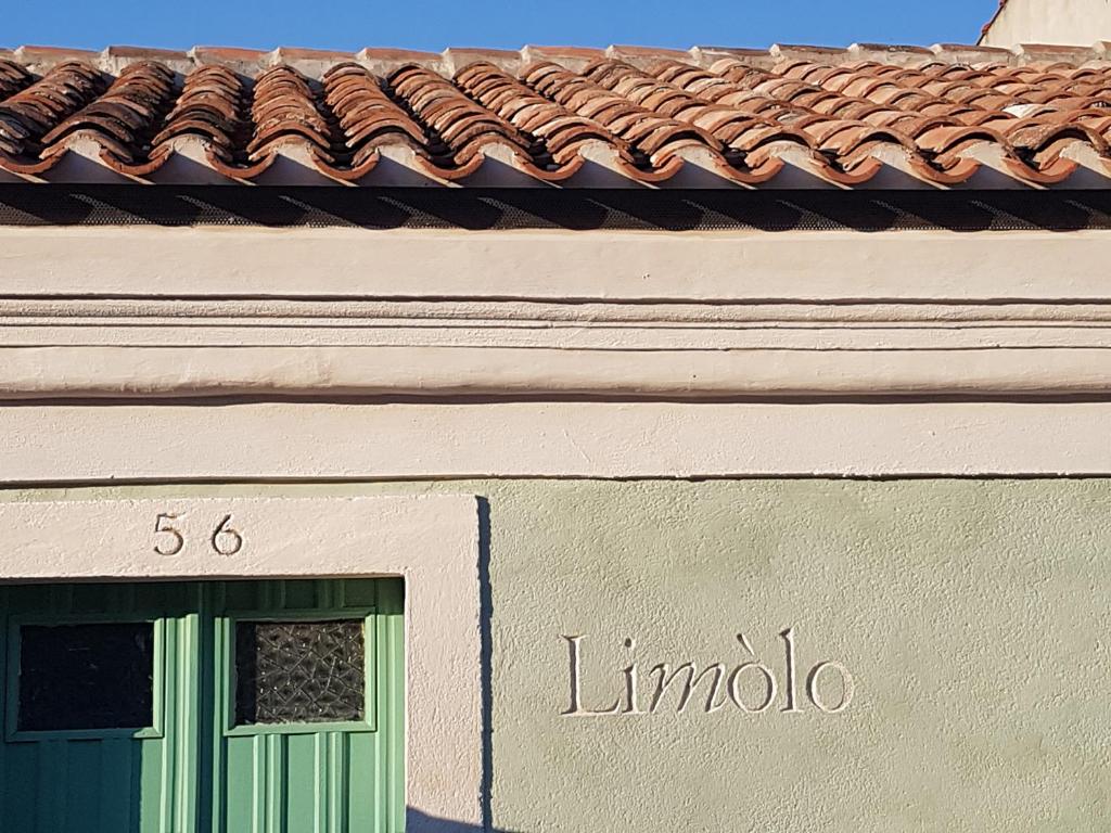 卡布拉斯Limolo Guesthouse的一座带绿门和屋顶的建筑