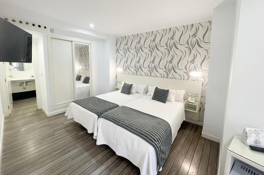 科尔多瓦奥萨里奥之门精品酒店的卧室配有白色的床和墙壁
