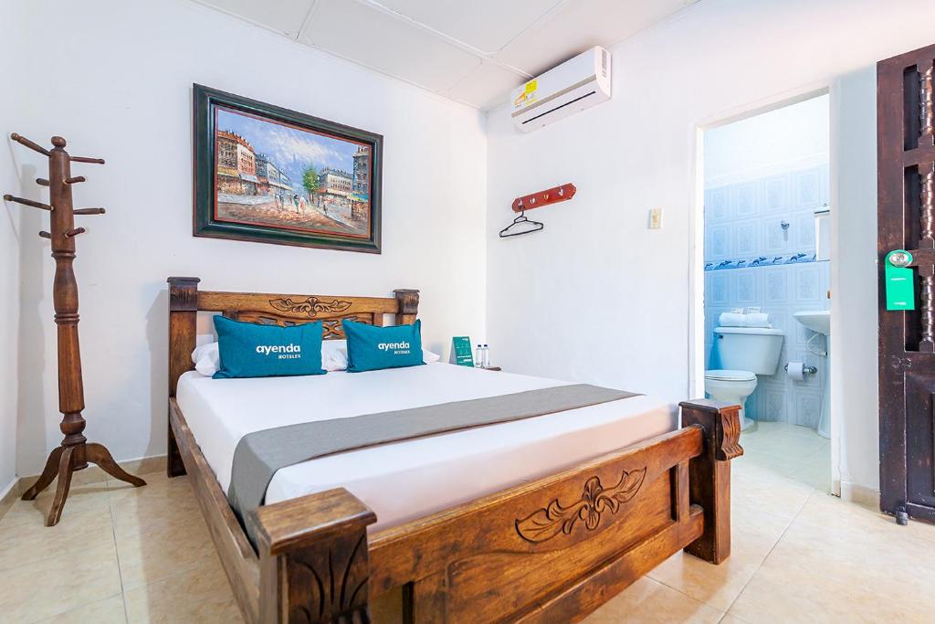 巴耶杜帕尔Hotel Colonial La Casa De Siempre的一间卧室配有一张带蓝色枕头的木床。