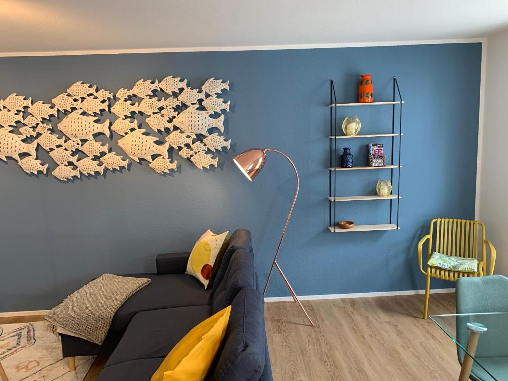 梅尔斯堡Ferienwohnungen Bohner/Ferienwohnung Maria的客厅配有黑色沙发和蓝色的墙壁