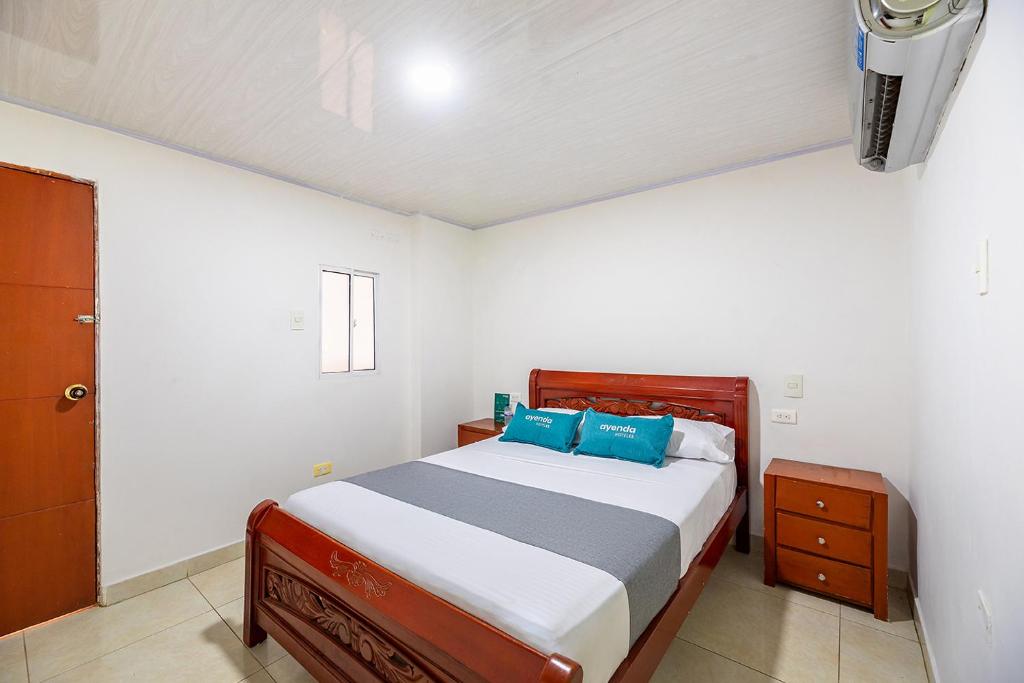 巴兰基亚Hotel Nuevo Yalu的一间卧室配有一张带蓝色枕头的床