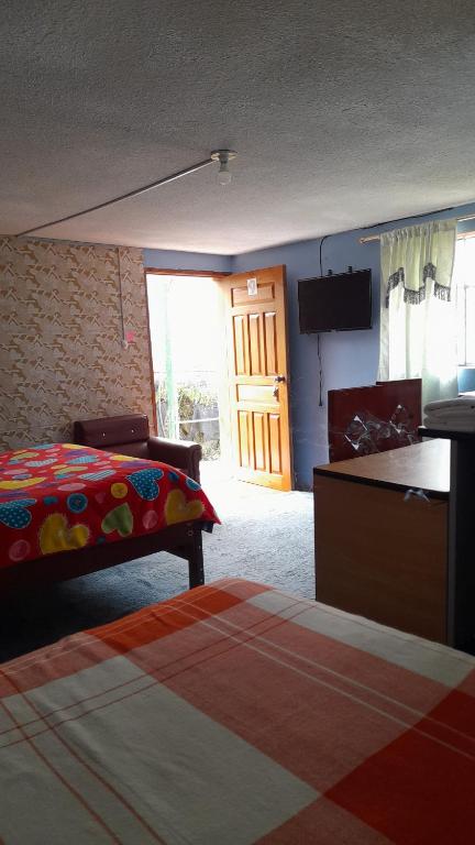 基多Hospedaje el Motilon的卧室配有床、电视和门