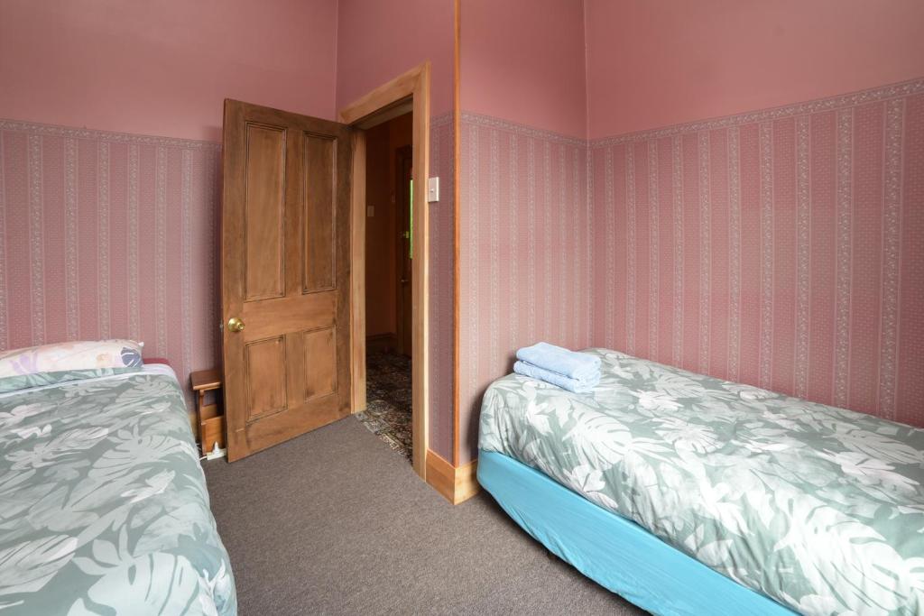 因弗卡吉尔Southern Comfort的配有粉红色墙壁的客房内的两张床
