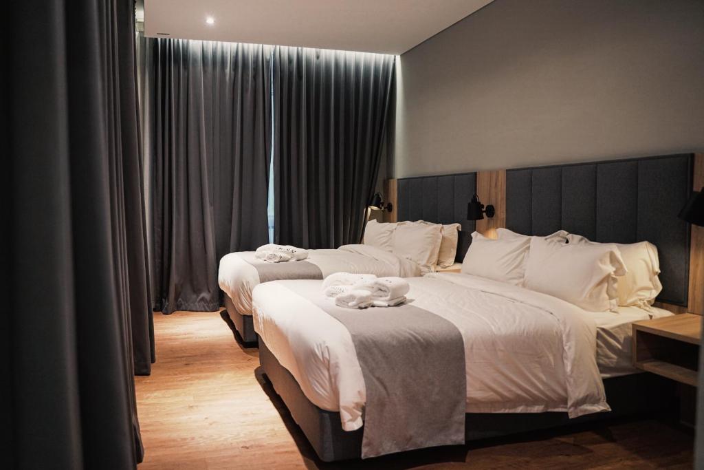 米里Amigo Hotel的酒店客房,配有两张带白色床单的床