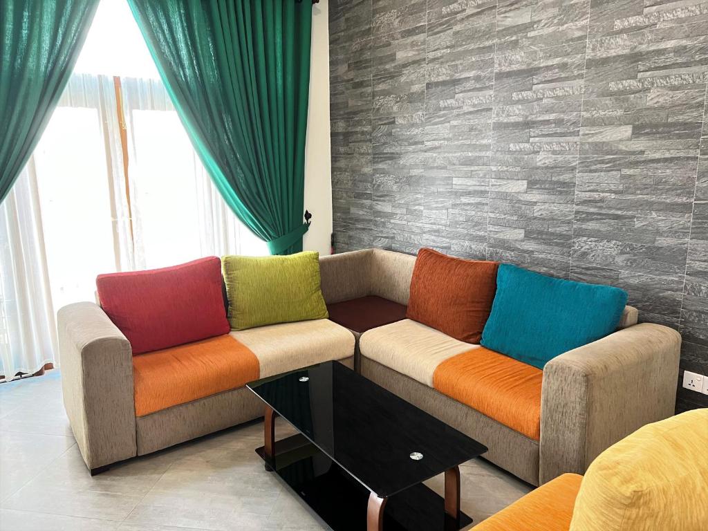 康提Hansons Homestay的客厅设有两张带色彩缤纷枕头的沙发