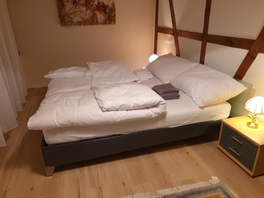 韦森Mornag AG Ferien Wohnung的一张带白色床单和枕头的床