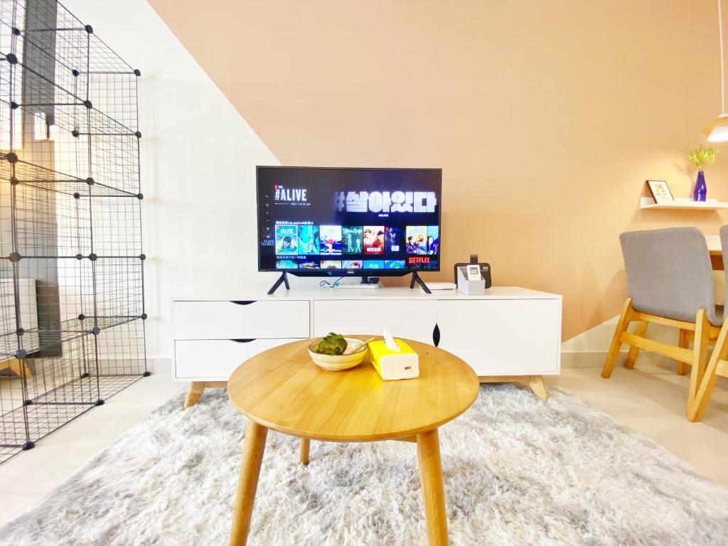 吉隆坡Lily and Loft - Queensville @ Kuala Lumpur - Netflix的客厅配有桌子和电视