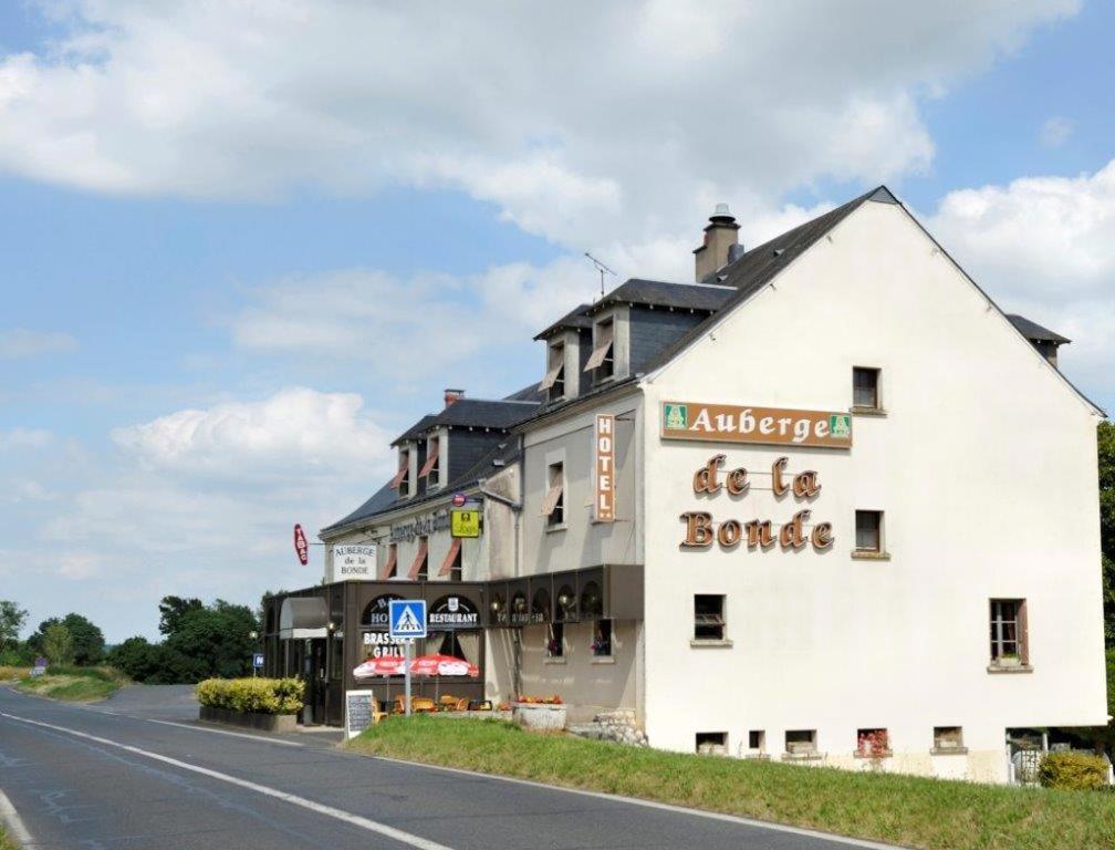 朗热Logis Hôtel Auberge de la Bonde的道路一侧的白色大建筑