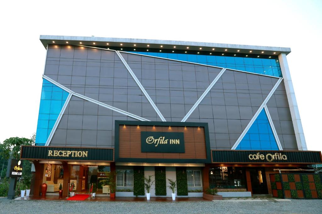 安加马尔伊ORFILA INN Airport Hotel的一座带灯的大玻璃建筑