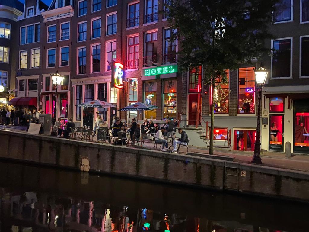阿姆斯特丹Hotel & bar Royal taste Amsterdam的一群人晚上坐在河边的桌子旁