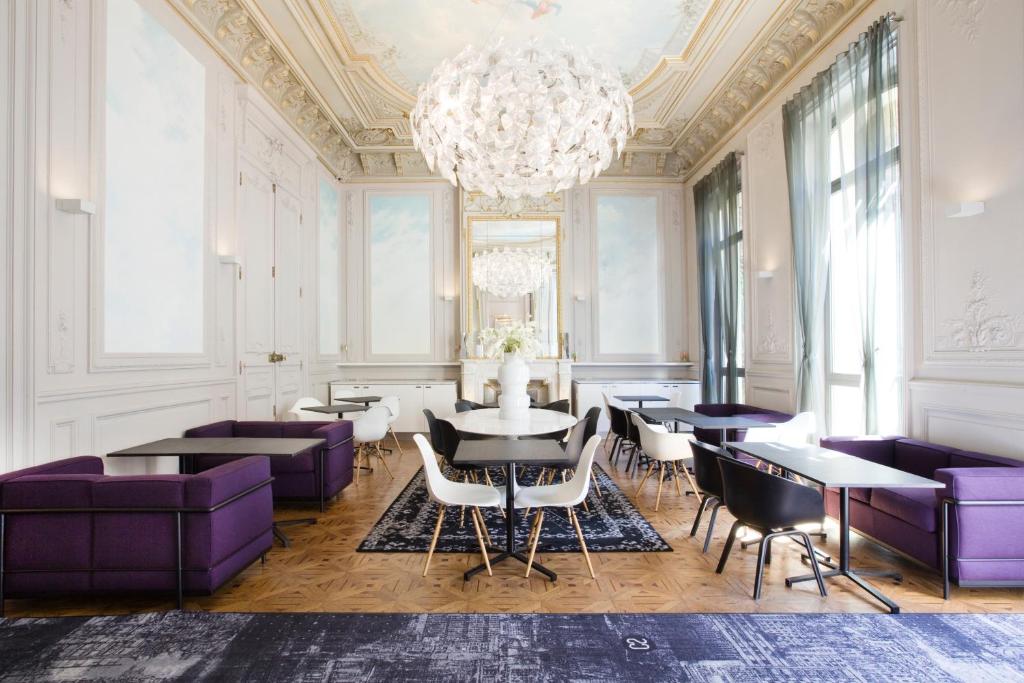 马赛C2酒店的一间用餐室,配有紫色家具和吊灯