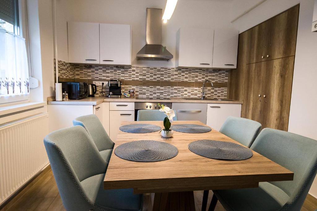 基什孔豪洛什Thermal Next I Weninger Apartman Kiskunhalas的厨房配有木桌和蓝色椅子