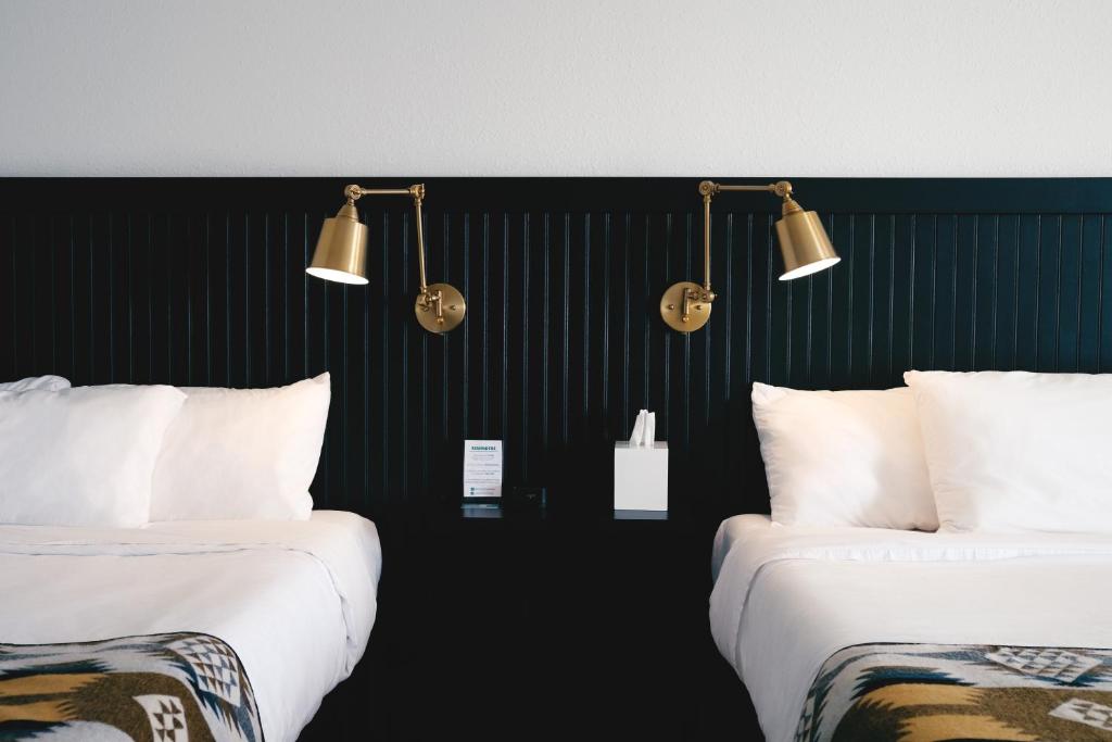 派恩代尔Jackalope Motor Lodge的两张睡床彼此相邻,位于一个房间里