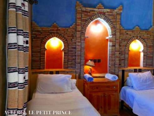 梅尔祖卡Hotel Riad Le Petit Prince的一间卧室设有两张床和砖墙