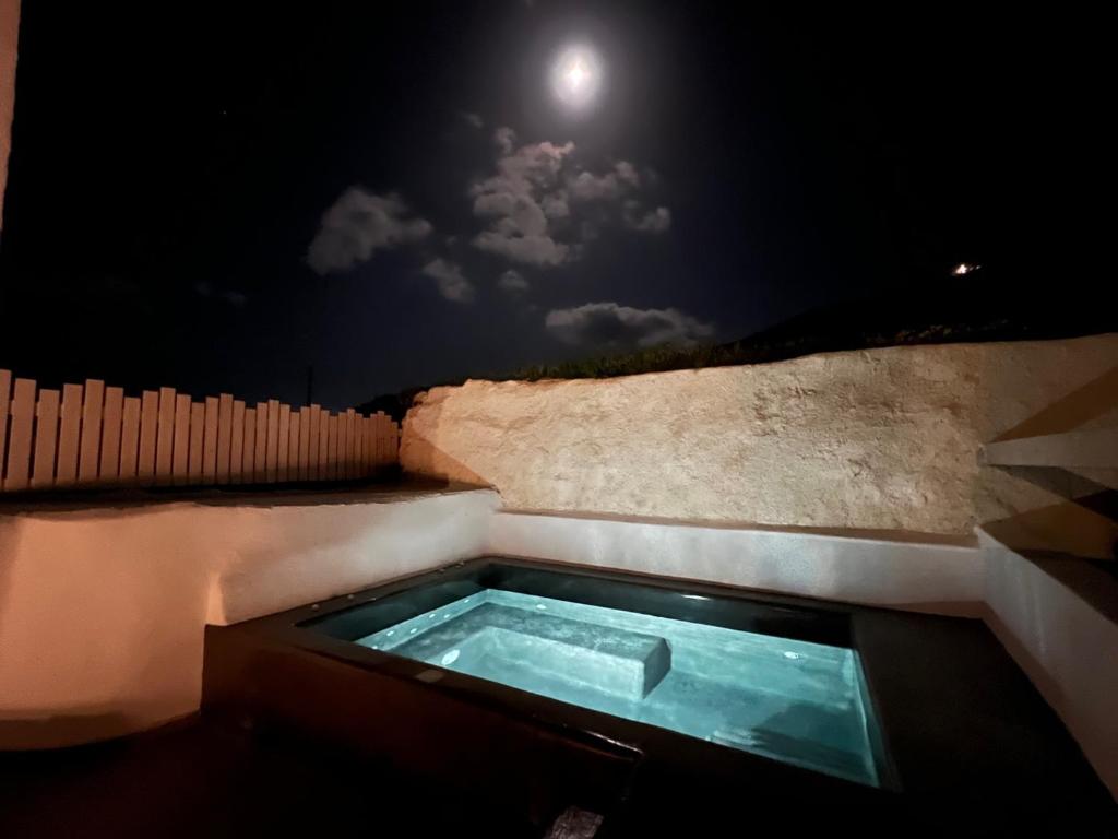 Éxo GoniáEpiskopi Estate Cycladic Villas的天空中带月亮的按摩浴缸