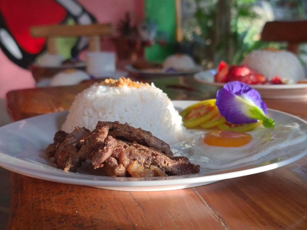 SalabusobCamp Paraiso Resort的餐桌上放着一盘饭和肉的食物
