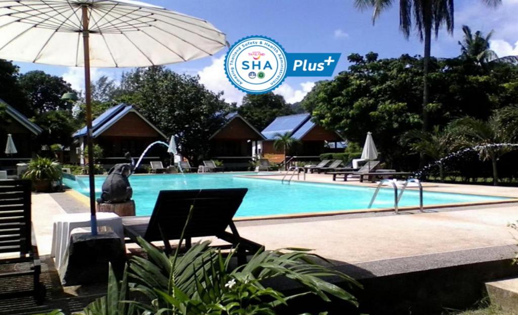 高兰Lanta Sunny House - SHA Extra Plus的一个带遮阳伞和标志的度假村游泳池