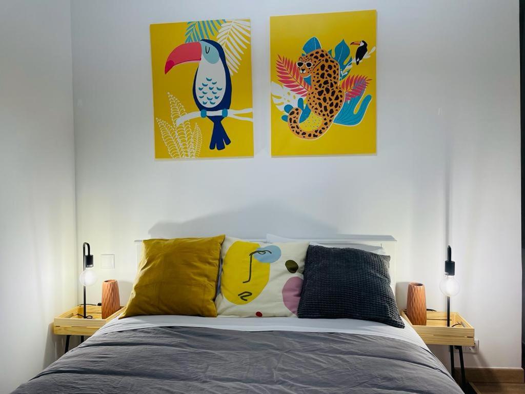 里斯本假日公寓的卧室配有两幅壁画和一张床