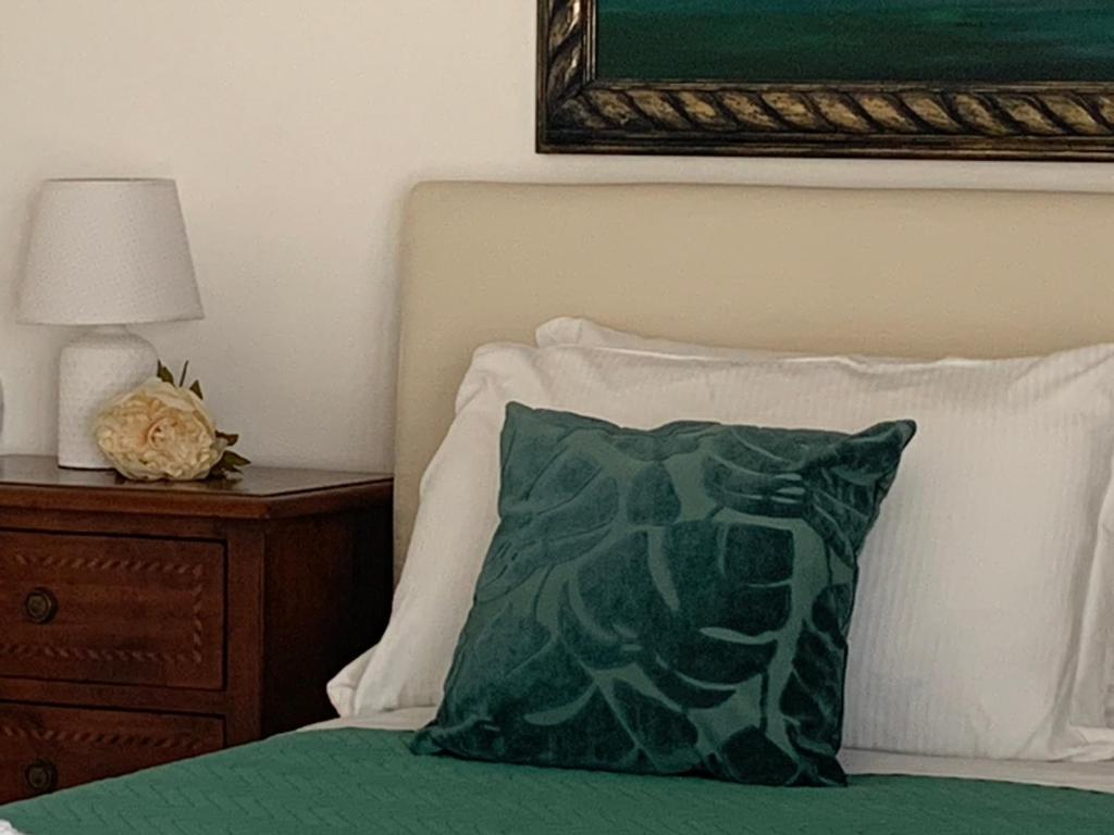 泰拉西尼Villa Serendipity Terrasini的床头柜旁边的床上的绿色枕头